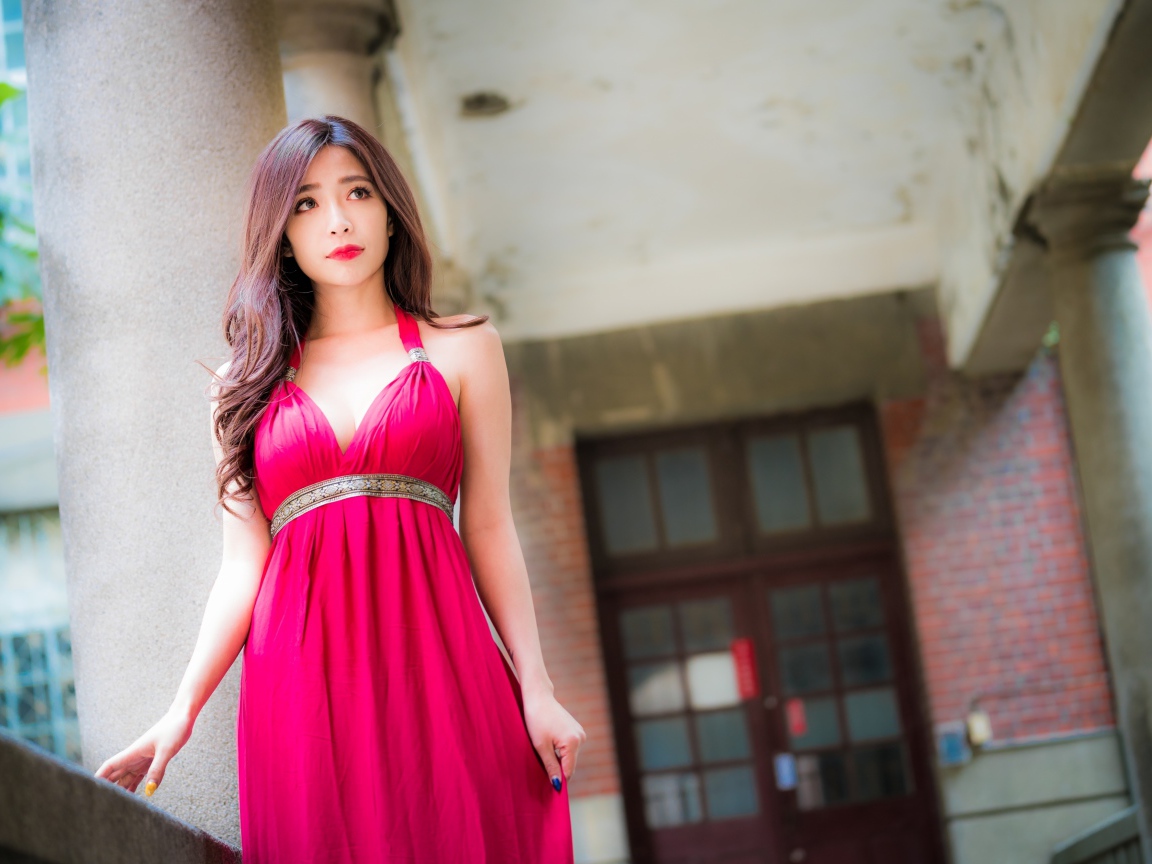 Девушка в красивом розовом платье у здания