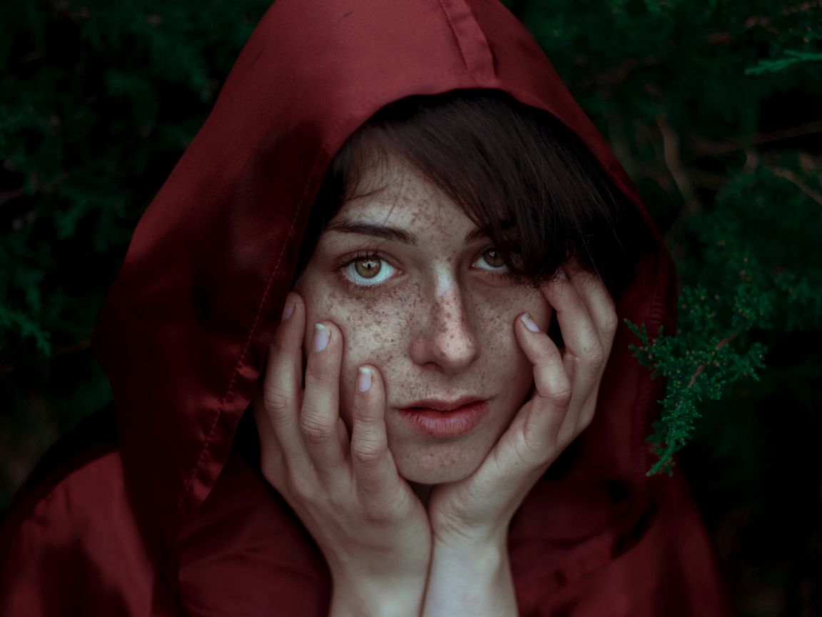 Девушка в красном плаще с веснушками на лице
