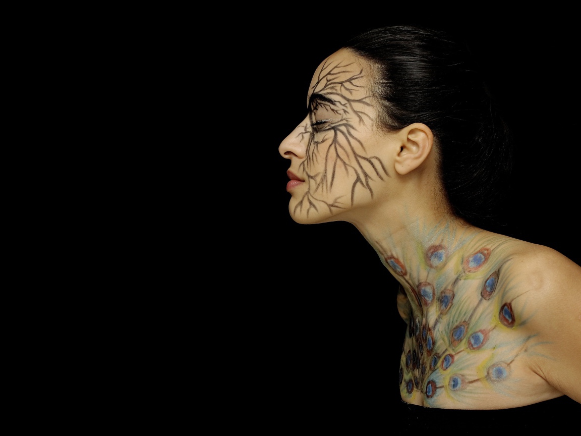 Девушка с рисунками на теле на черном фоне