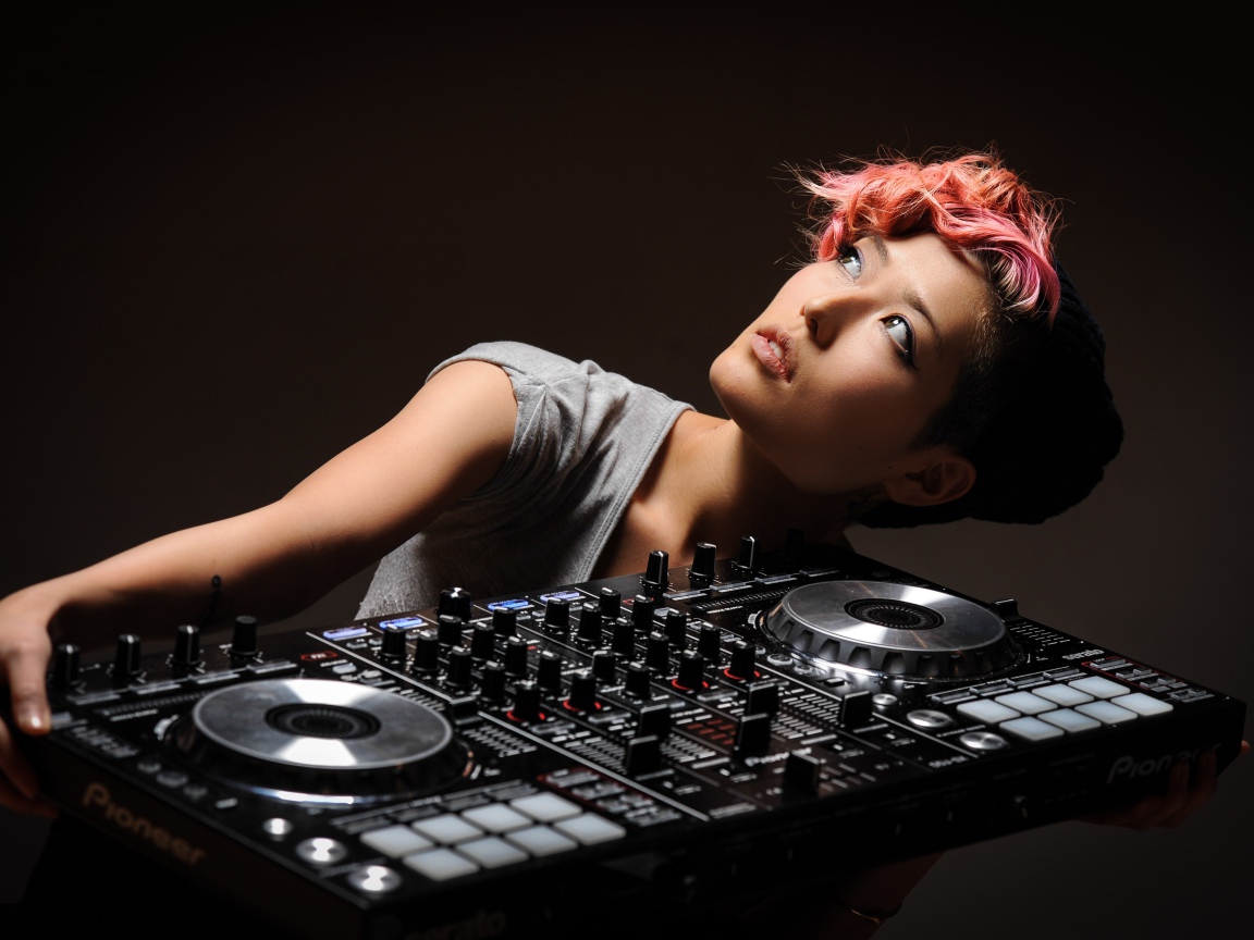 Девушка с розовой челкой с диджейским пультом в руках