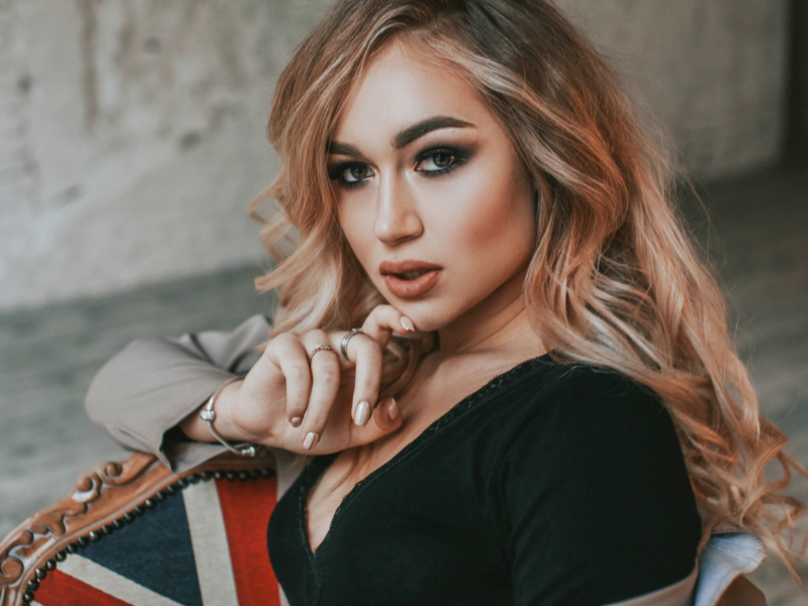 Горячая девушка с макияжем сидит на стуле