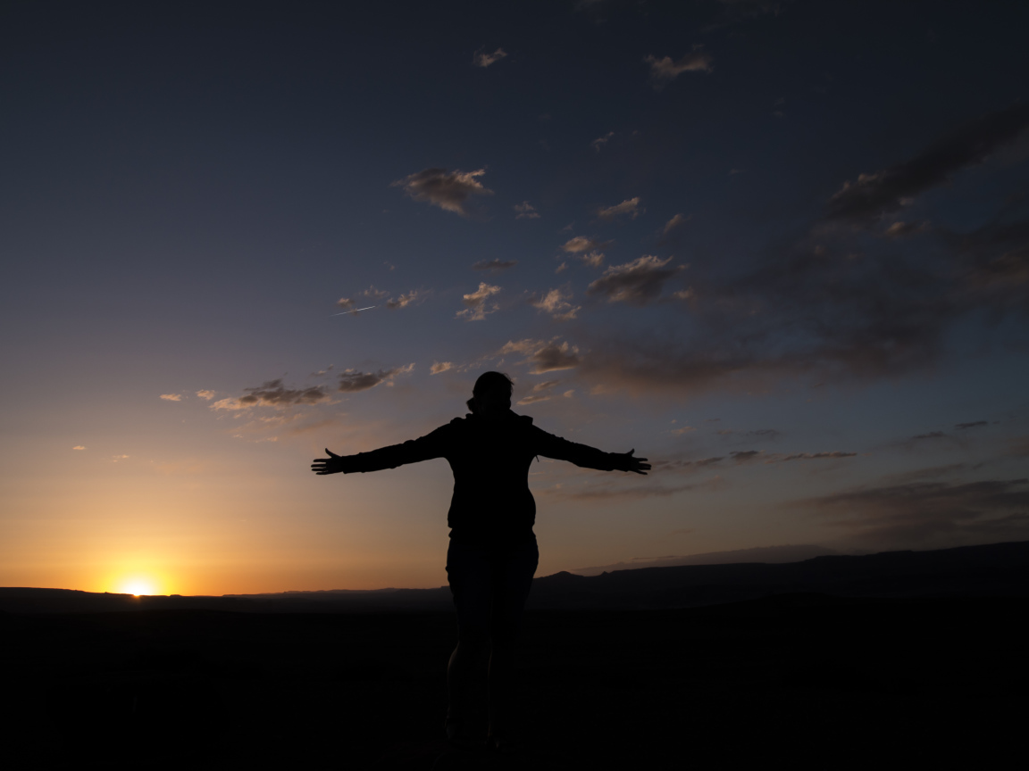 Силуэт девушки на фоне неба на закате