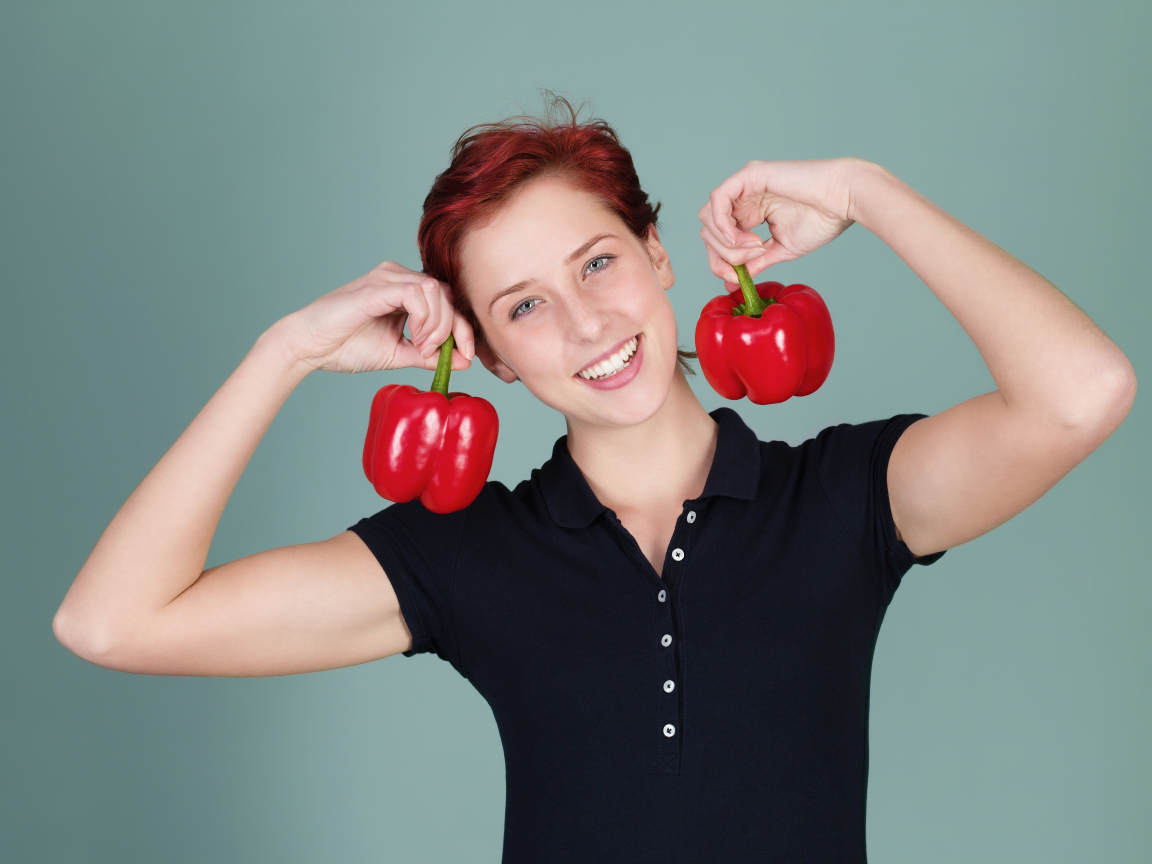 Улыбающаяся девушка с болгарским перцем в руках