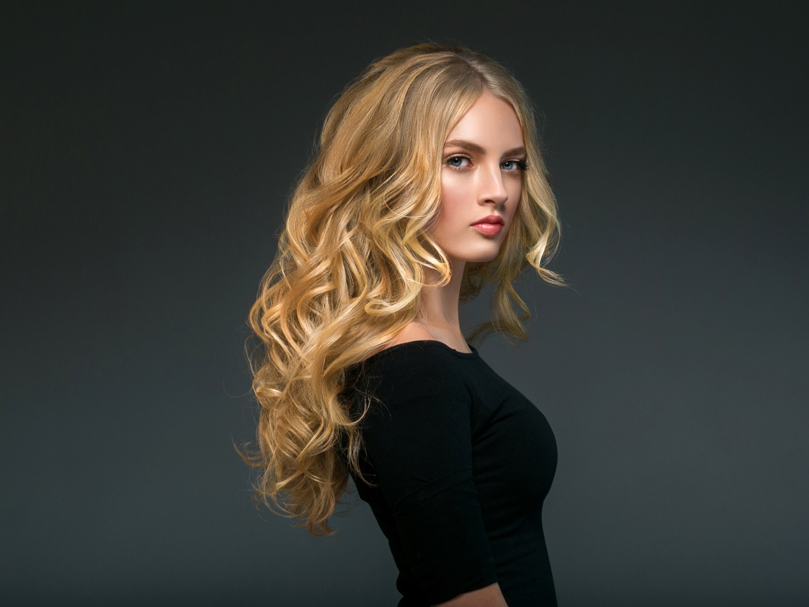 Стильная голубоглазая длинноволосая девушка в черном наряде