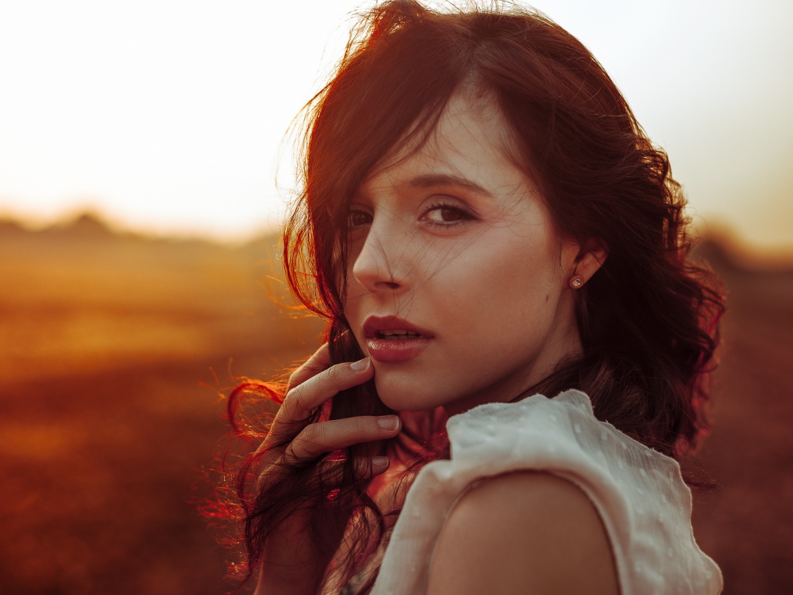 Ветер развивает волосы молодой девушки 