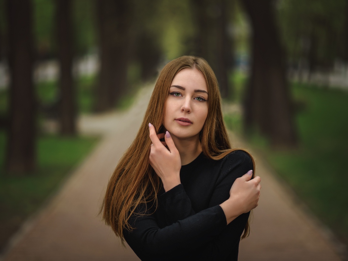 Молодая девушка в черном наряде в парке