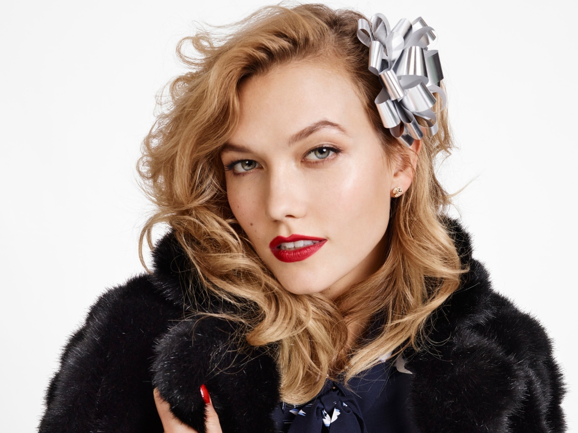 Модель Карли Клосс в черной шубе на белом фоне