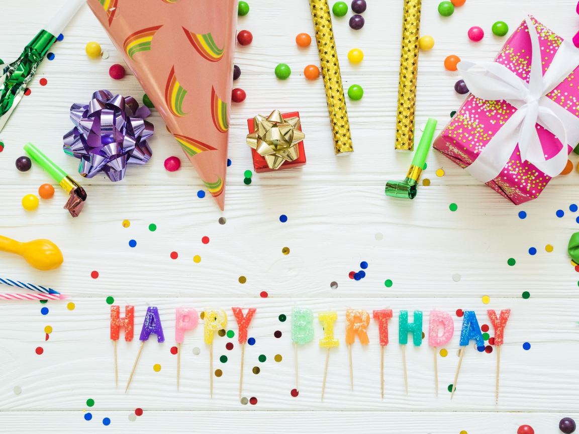 Надпись с Днем рождения на столе с подарками и украшениями