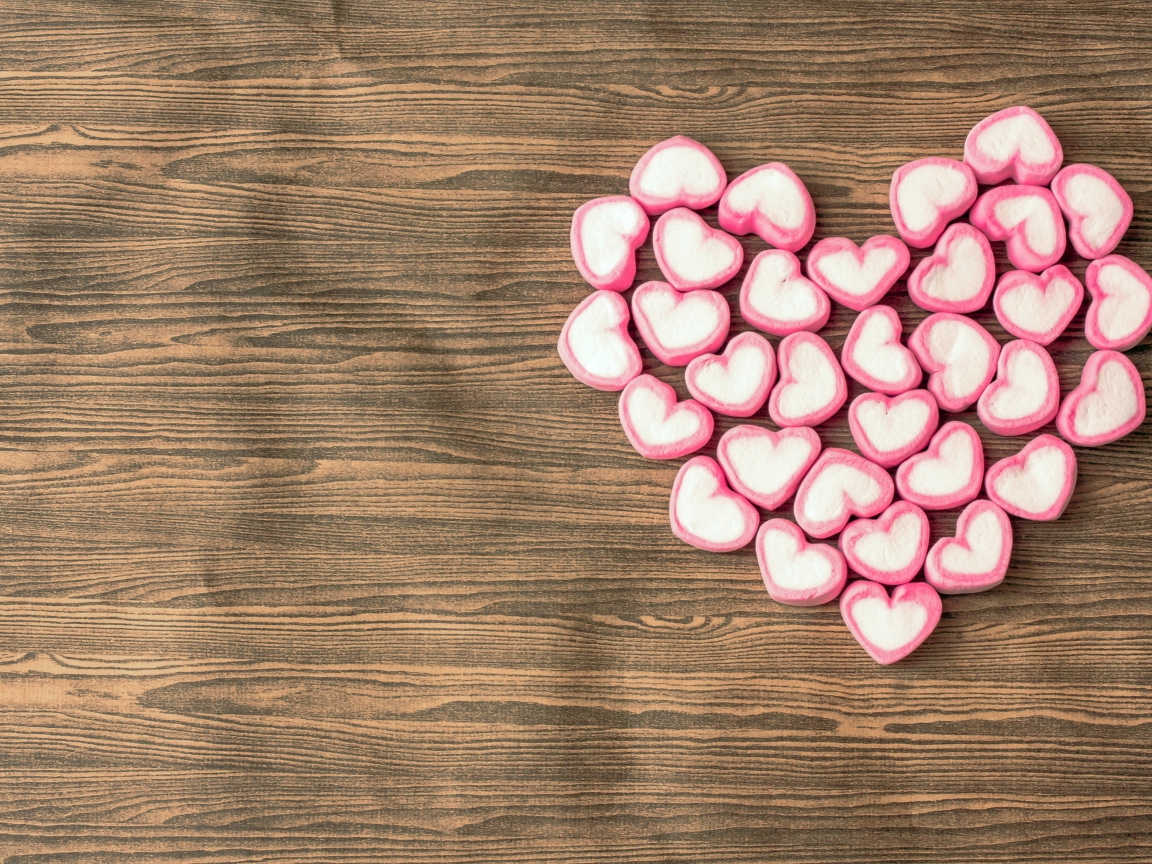 Сердце из конфет на деревянном столе