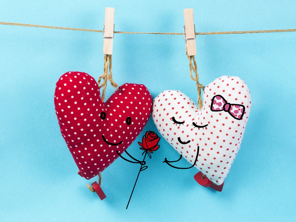 Два сердечка на прищепках на веревке на голубом фоне
