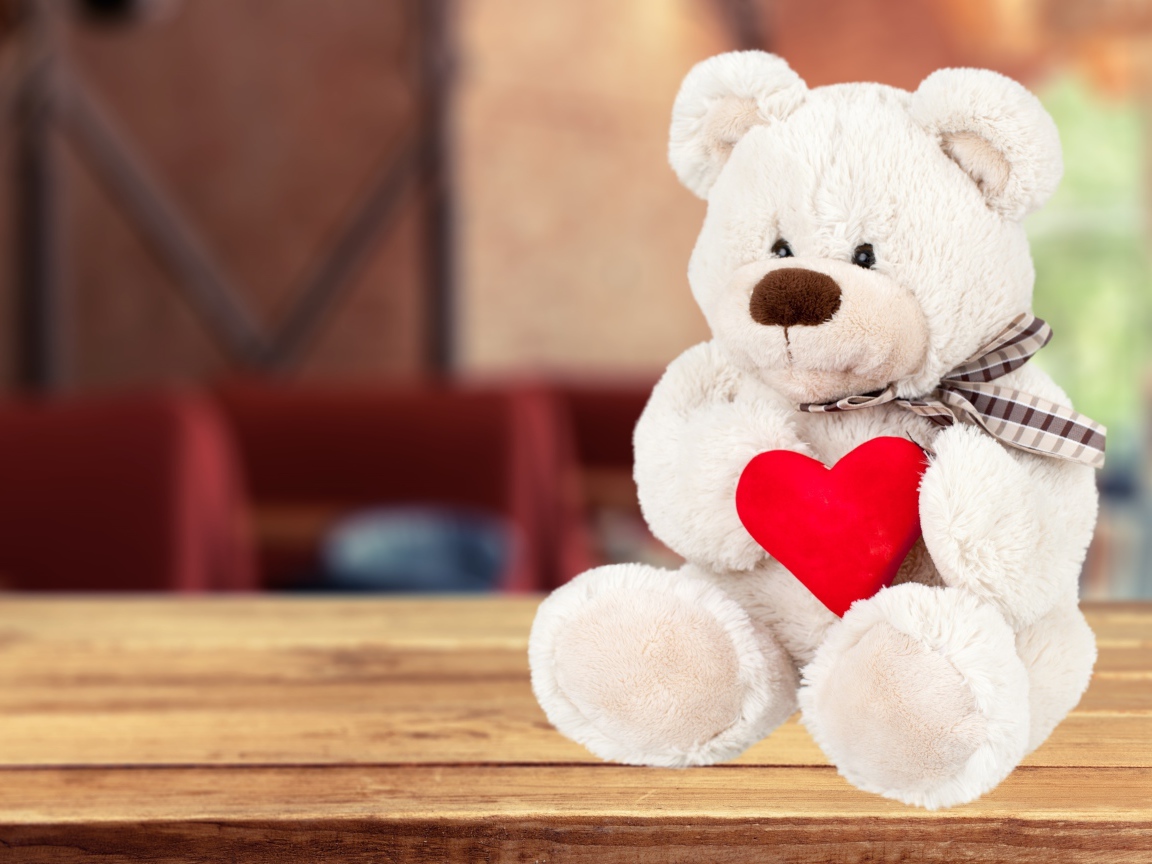 Белый плюшевый мишка с красным сердцем