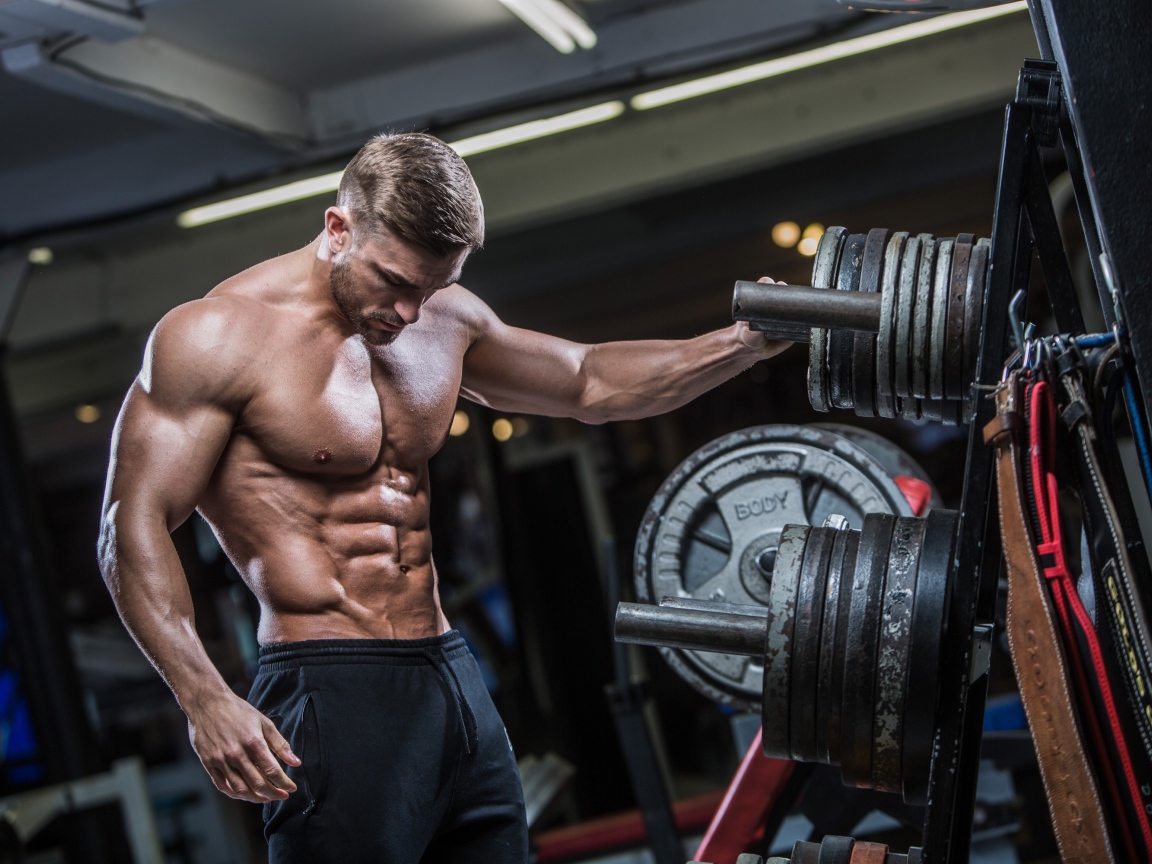 Красивый мужчина с накаченным телом в спортзале