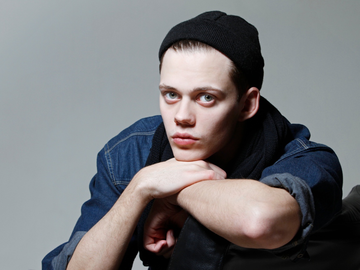 Молодой актер Билл Скарсгорд в черной шапке