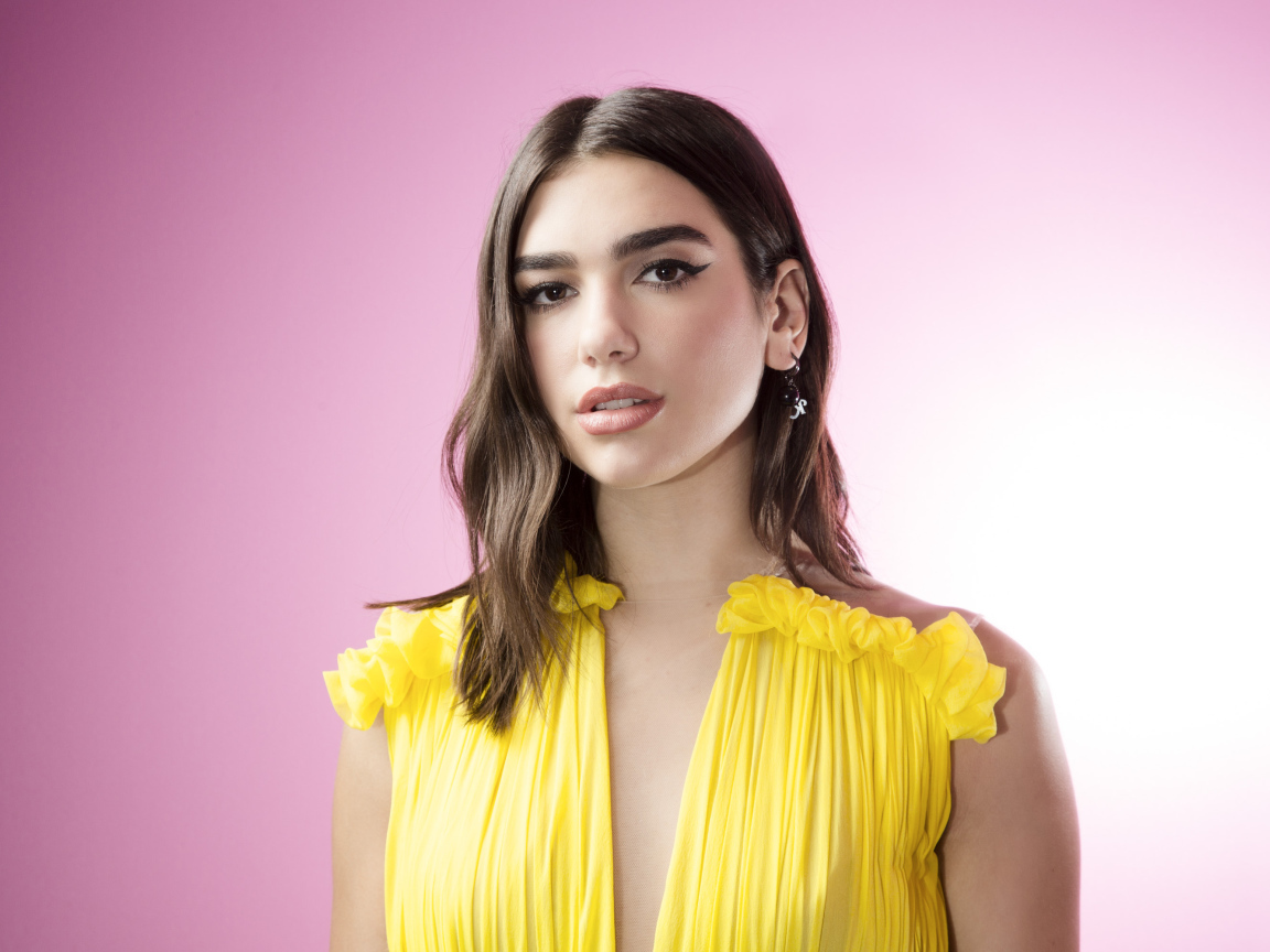 Милая девушка, певица Дуа Липа в желтом платье на розовом фоне