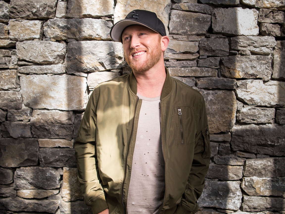 Музыкант Коул Суинделл в бейсболке у стены