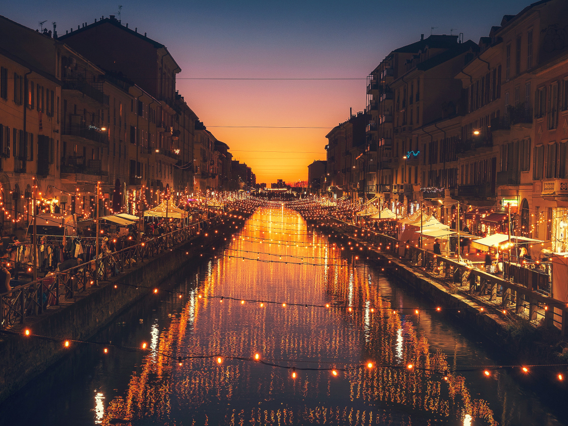 Яркие зажженные лампы над водным каналом