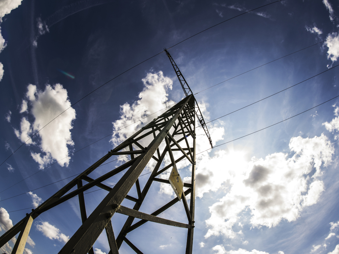 Столб линии электропередач на фоне голубого неба с облаками