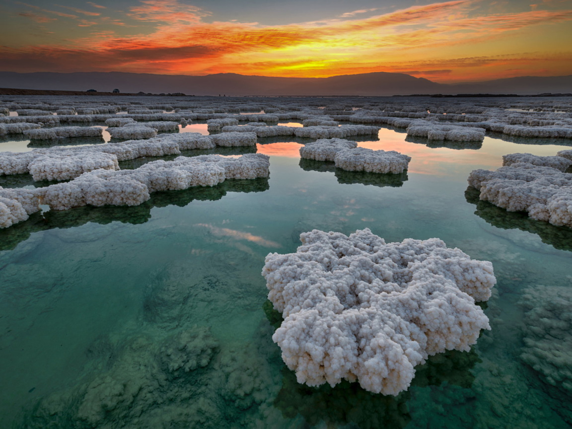 Соляные отложения в воде под красивым небом на закате