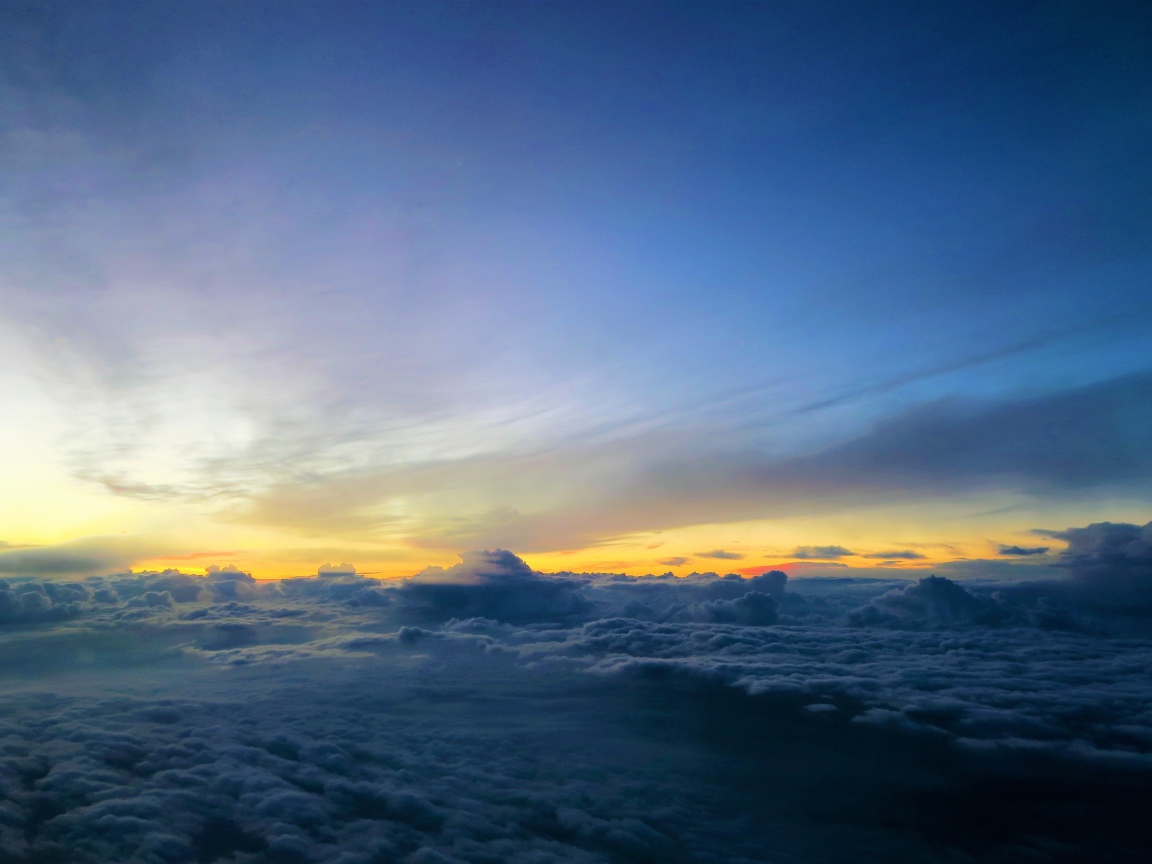 Белые низкие облака под голубым небом на рассвете