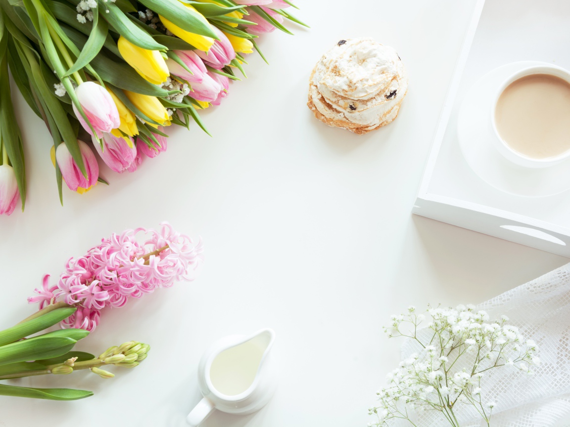 Букет тюльпанов и гиацинт на столе с пирожным и чашкой какао 