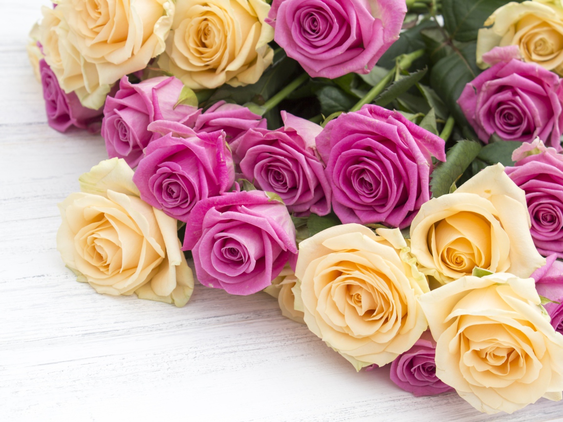 Розовые и белые розы на белом столе 