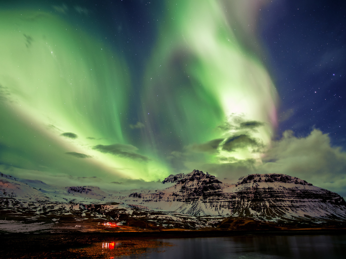 Northern lights over snowy mountains, Iceland