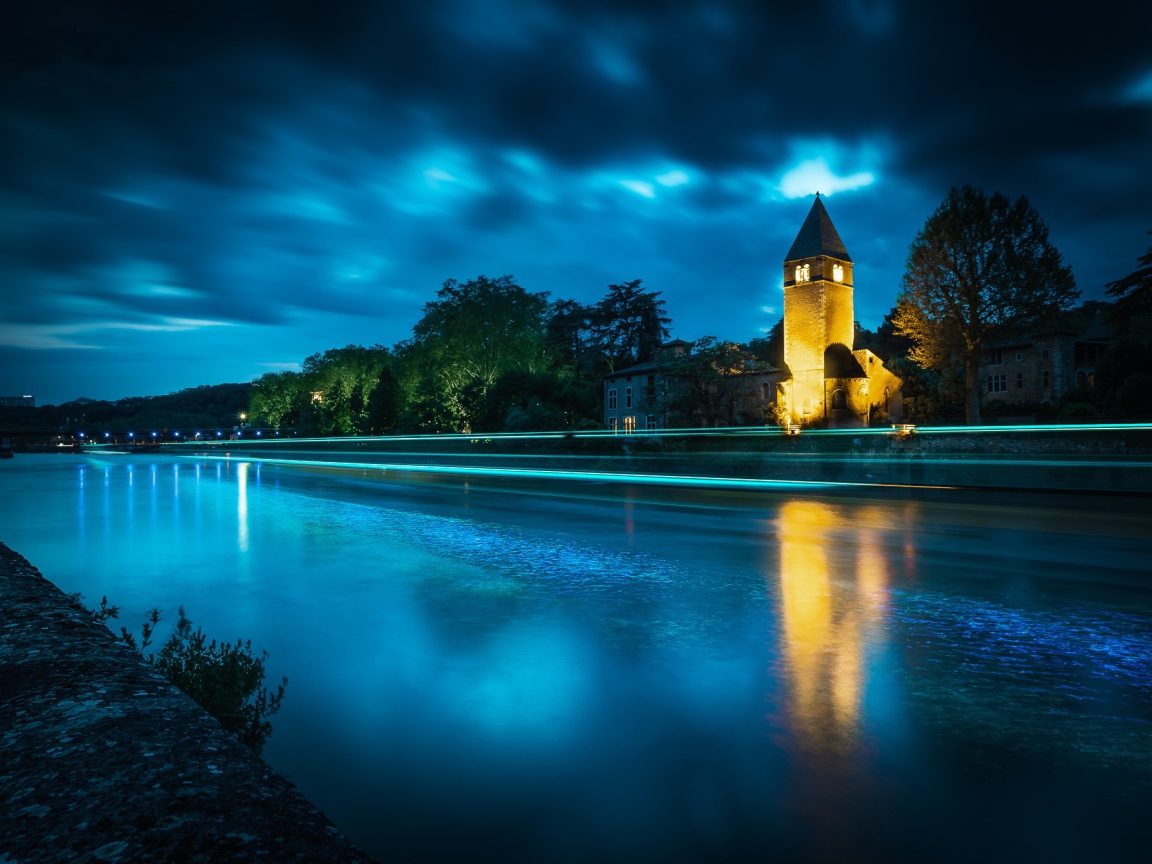 Башня на берегу реки ночью 