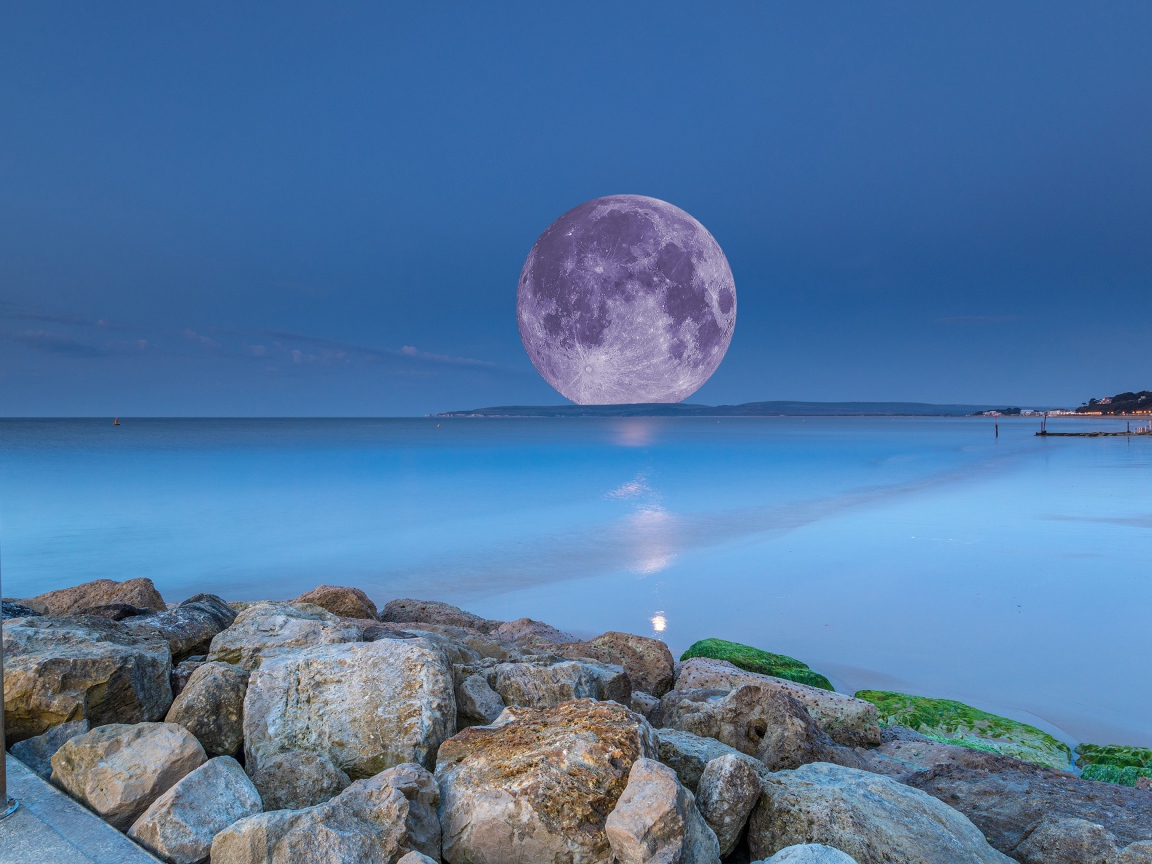 Огромная белая луна на горизонте в море