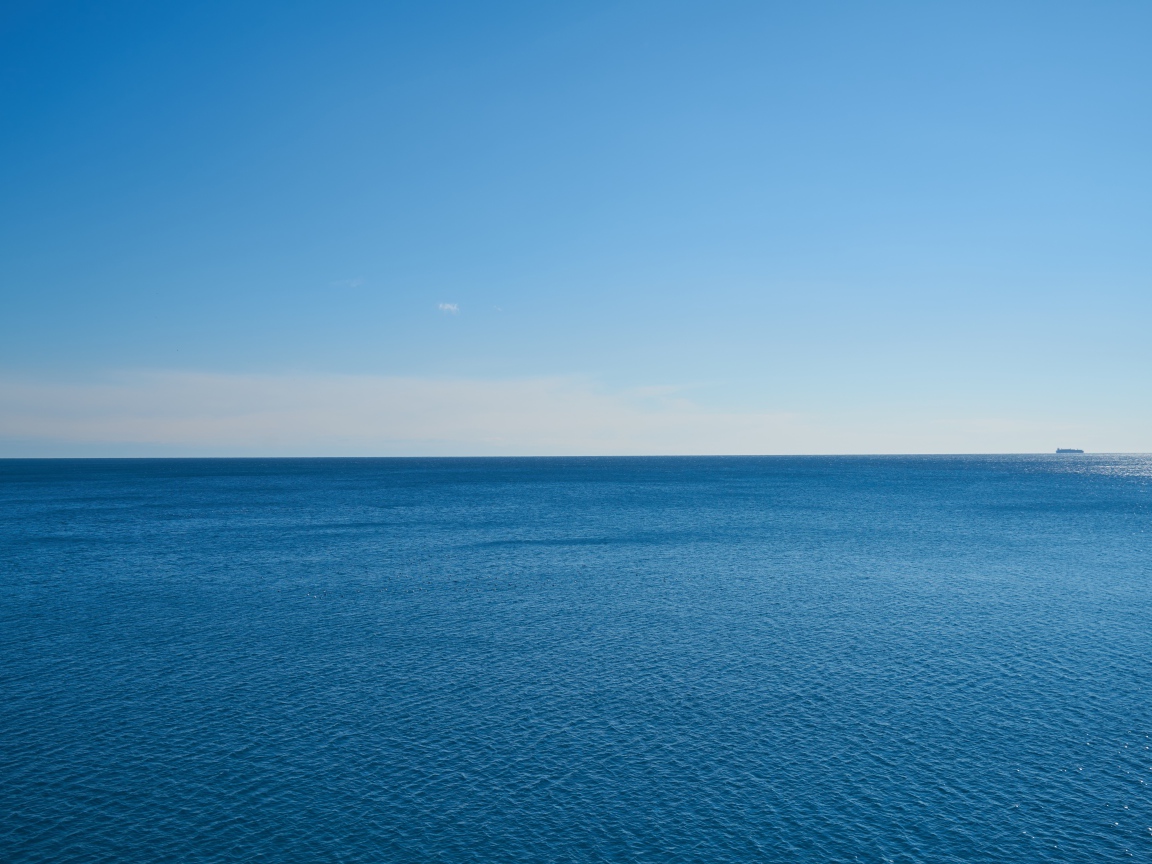 Calm sea water against a blue sky