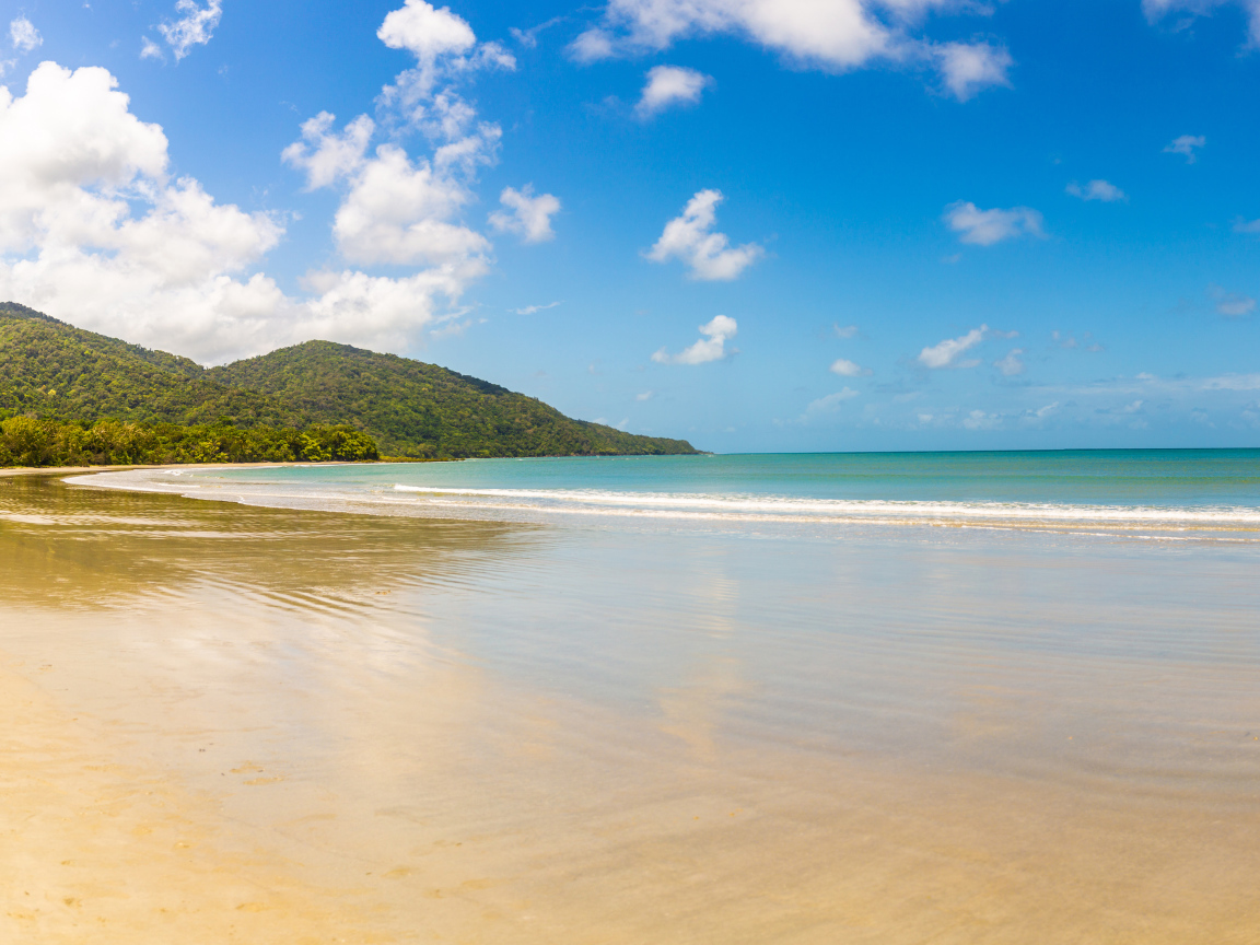 Спокойные волны на песке под красивым голубым небом