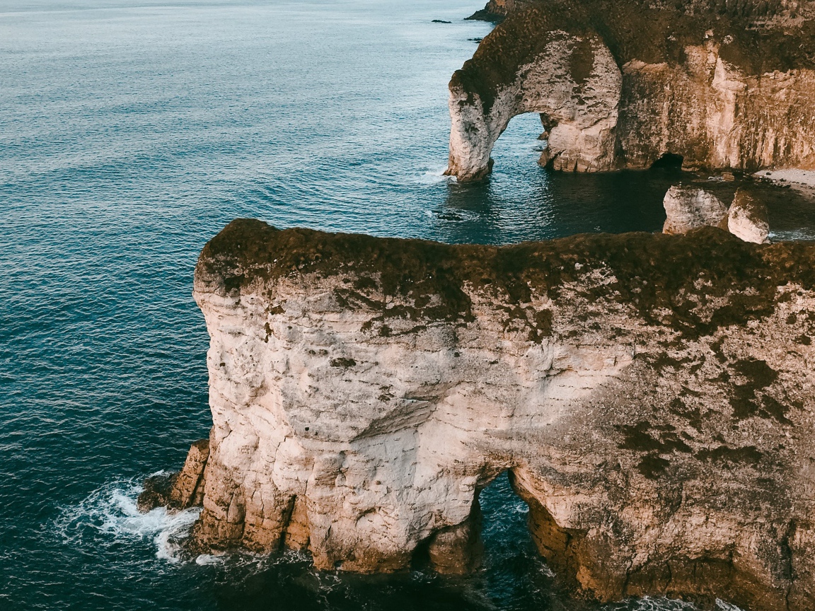 Каменные утесы с арками в океане 