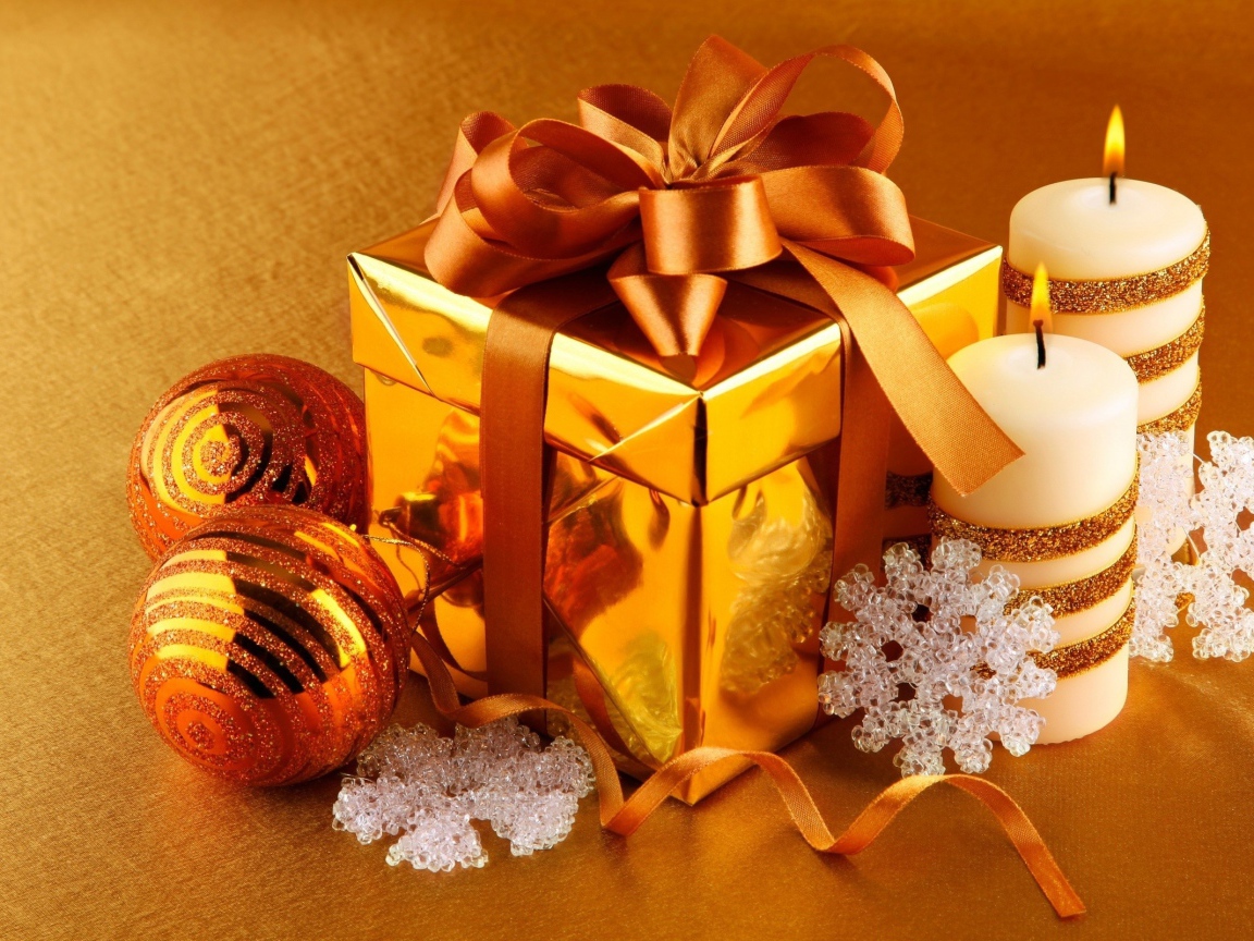 Подарок, елочные шарики и зажженные свечи на новый год 2020 