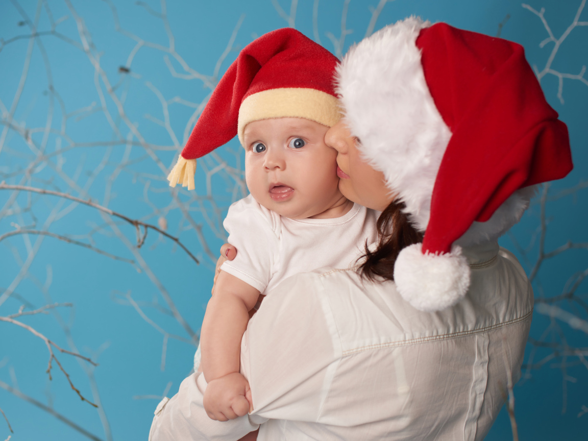 Маленький ребенок в новогоднем костюме на руках у мамы