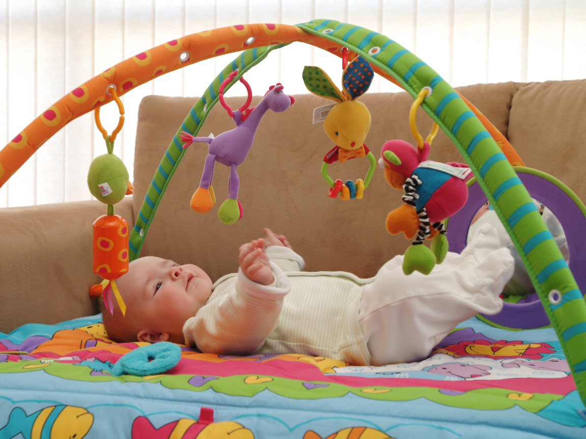 Грудной малыш играет с игрушками