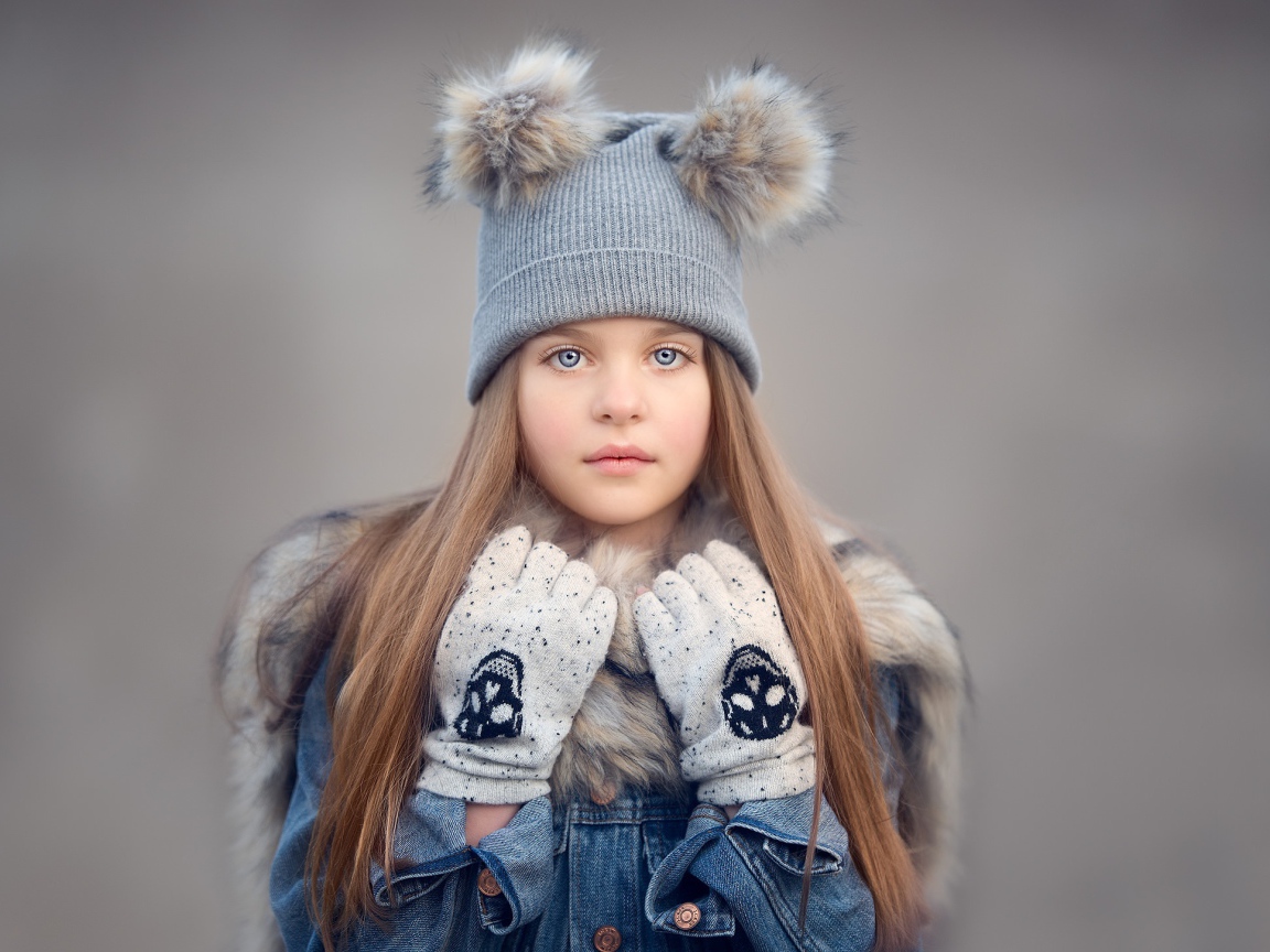 Красивая голубоглазая девочка в теплой шапке