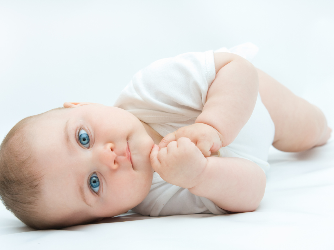 Забавный голубоглазый малыш на белом фоне