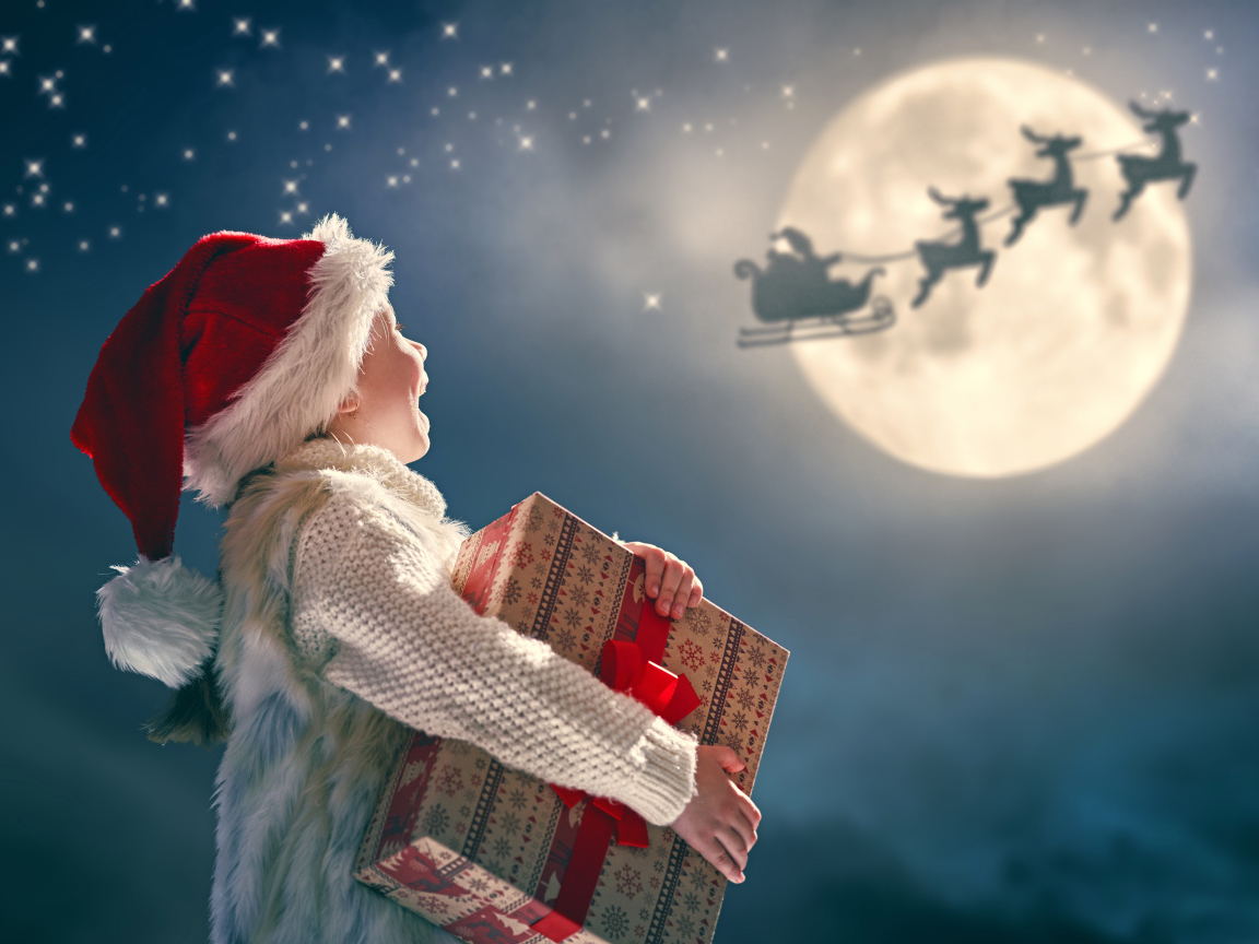 Маленький мальчик с подарком смотрит на улетающего Санта Клауса