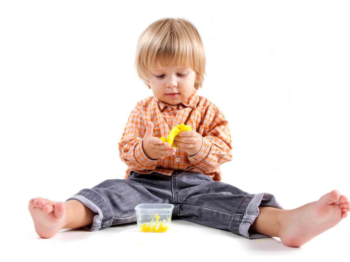 Маленький мальчик с игрушкой на белом фоне