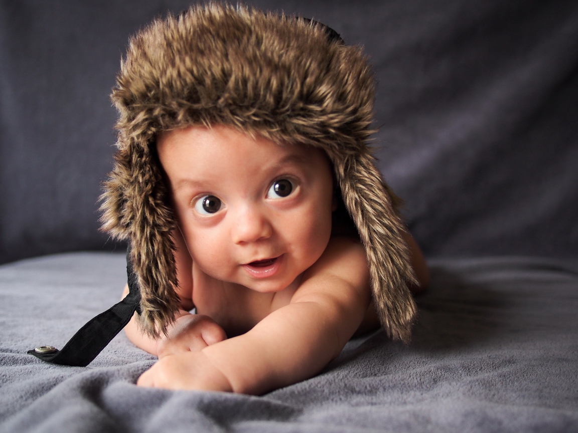 Маленький кареглазый ребенок в теплой шапке