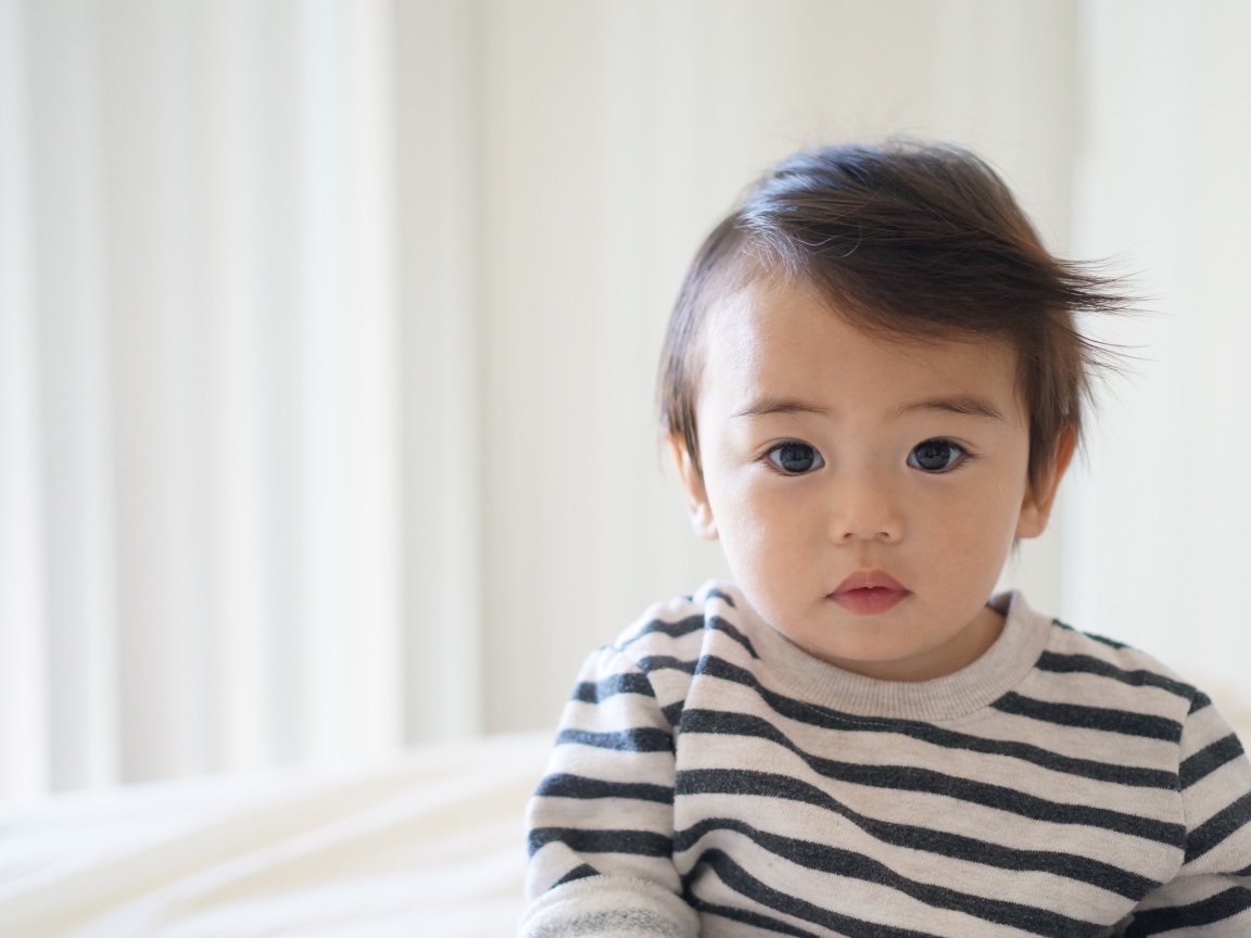 Маленький кареглазый мальчик в полосатом свитере