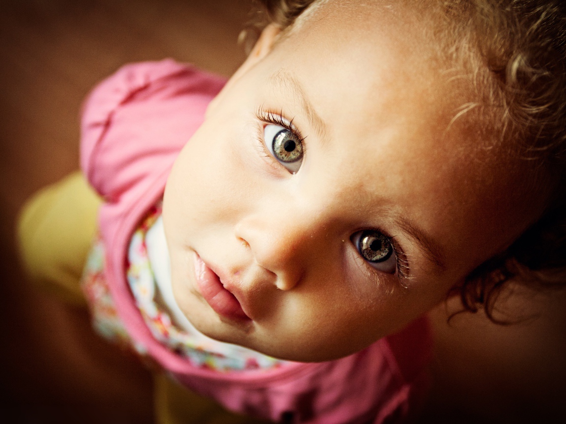 Маленькая девочка крупным планом смотрит вверх 