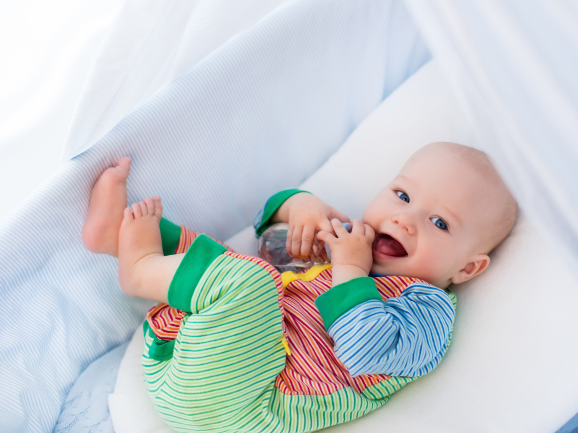 Улыбающийся малыш в колыбели 