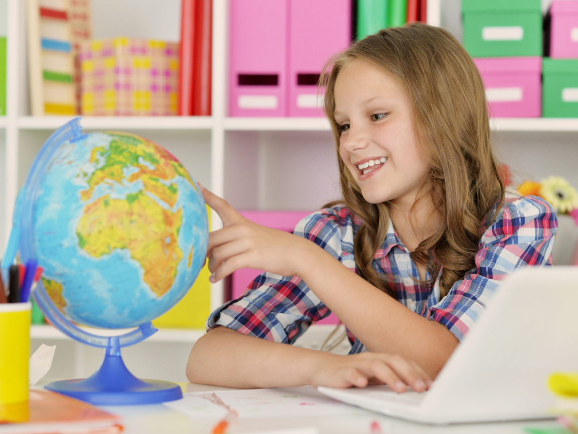 Улыбающаяся девочка школьница с глобусом