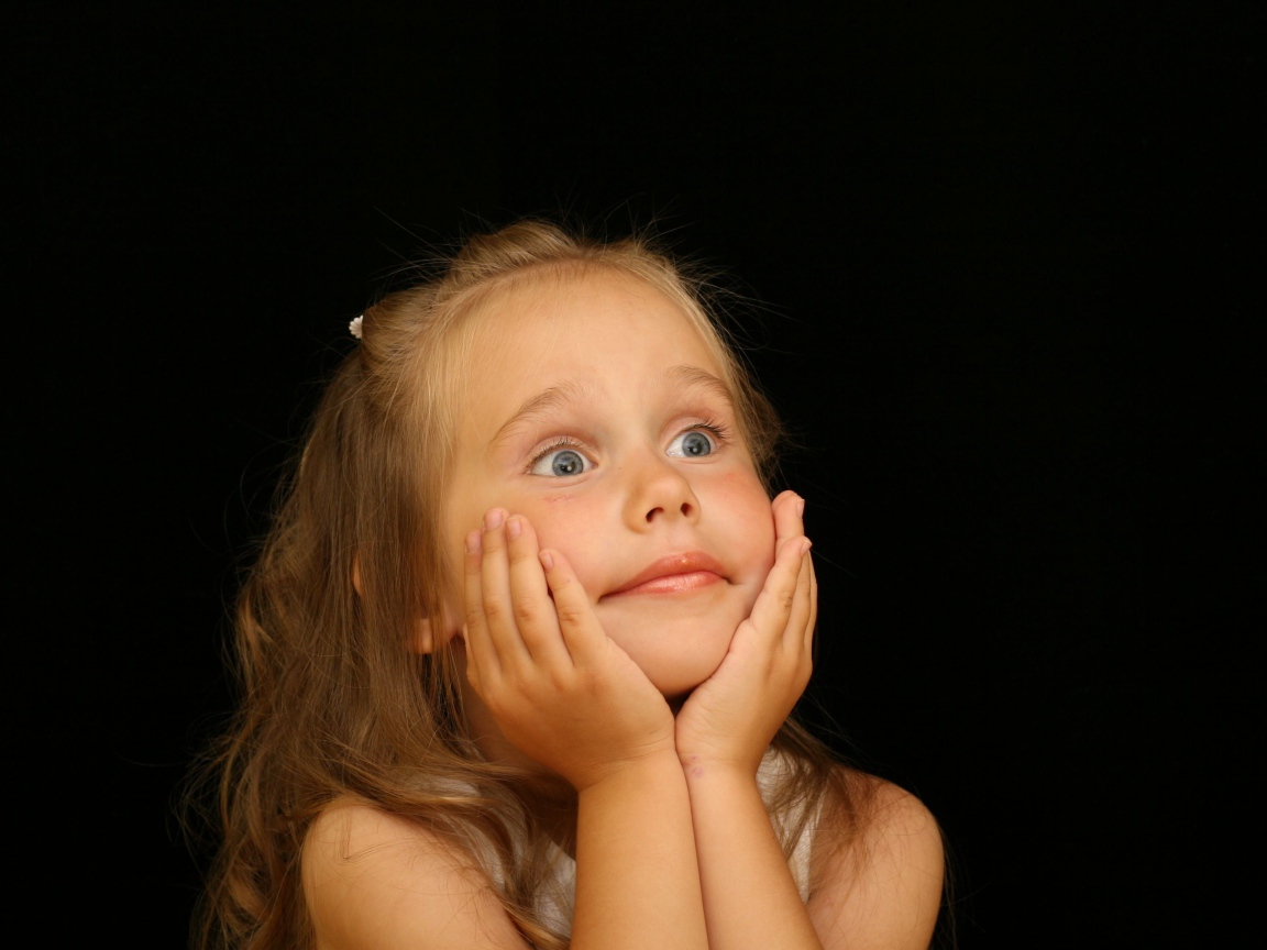Удивленная маленькая девочка на черном фоне