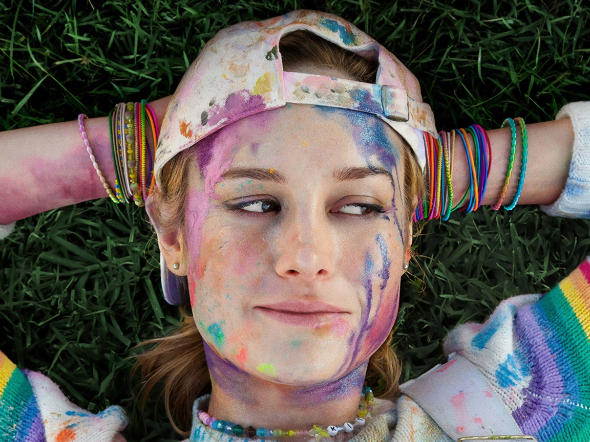 Актриса Бри Ларсон с лицом в краске лежит на траве