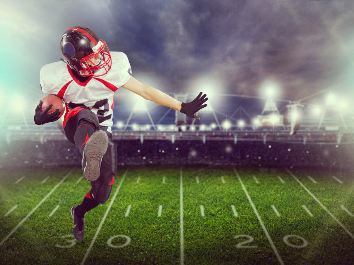 Игрок в американский футбол с мячом на поле