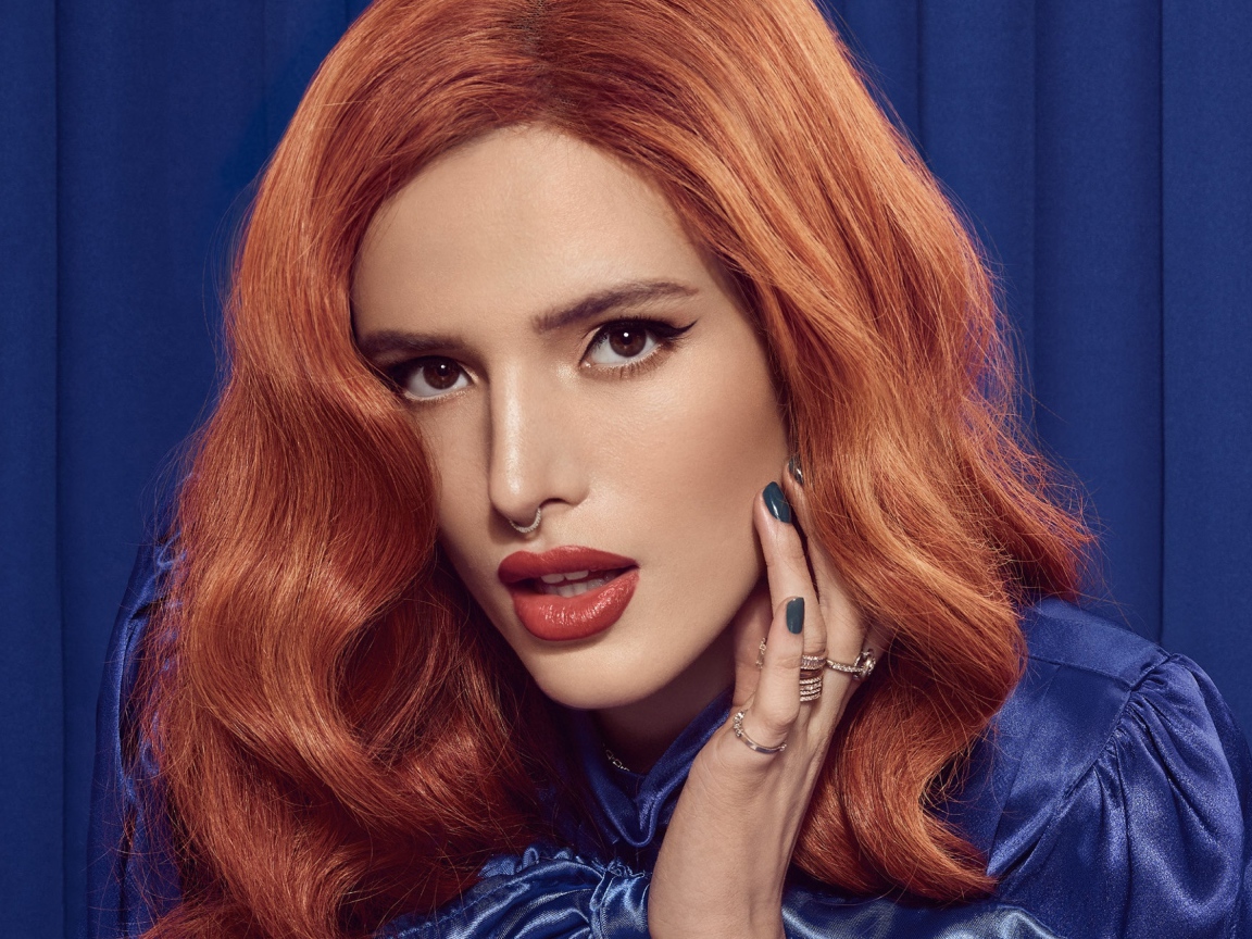 Рыжеволосая актриса Белла Торн на синем фоне