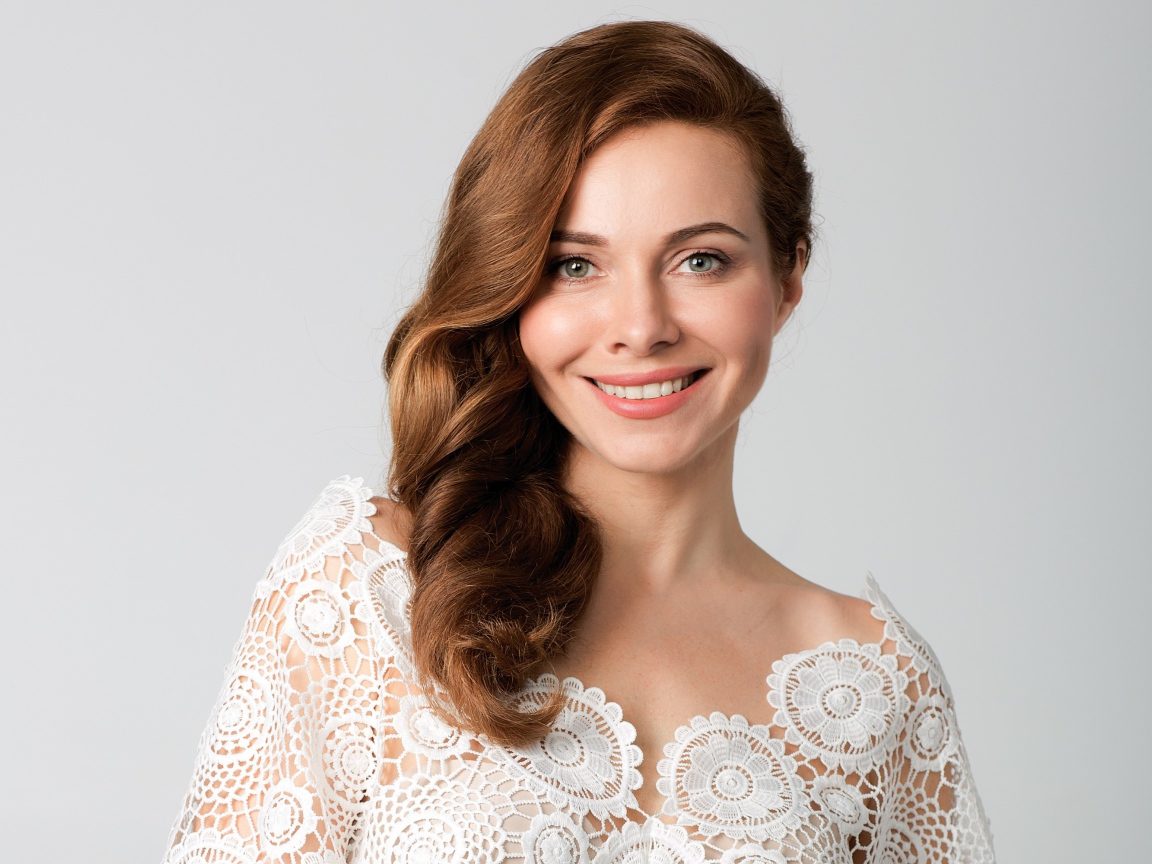 Улыбающаяся милая девушка, актриса Екатерина Гусева на сером фоне