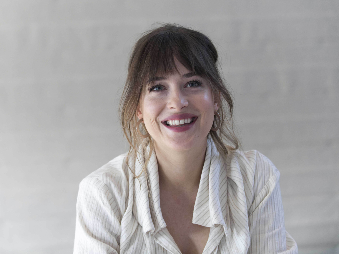 Улыбающаяся девушка актриса Дакота Джонсон в рубашке