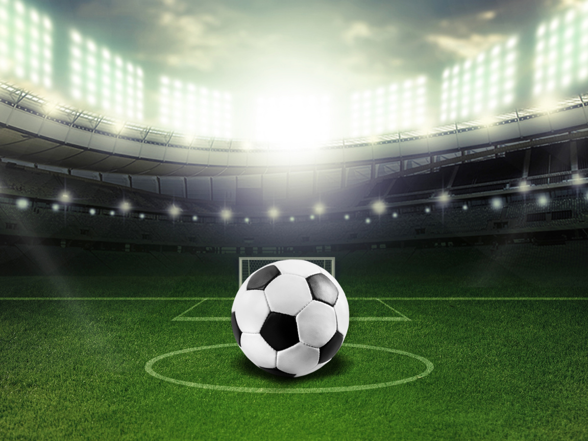 Футбольный мяч лежит на футбольном поле на стадионе